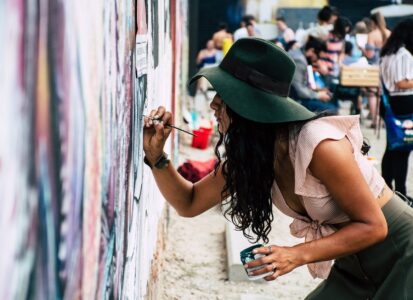 photo of woman painting on wall