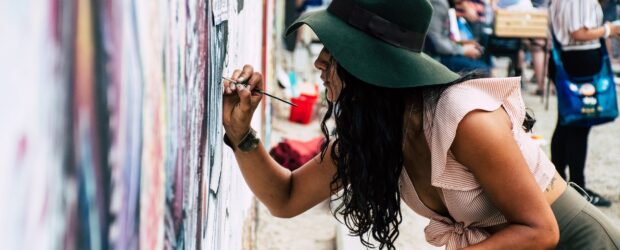 photo of woman painting on wall